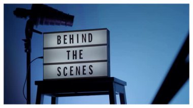 Kamera çerçevesinin önündeki sahne ışığı kutusunun arkasında. Sahne arkasında beyaz ışık kutusu üzerindeki siyah metin. Film yapımcısı ya da film stüdyosu için dekor. B-roll video yapımı için görüntü.