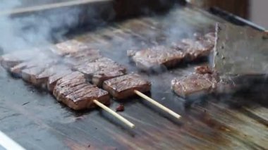 Şef, Japon Wagyu bifteğini ya da etini alev makinesiyle şişledi. Izgara tava ve meşale ile nefis bir şekilde ızgara et. Japonya 'da canlı sıcak alevlerle sokak yemekleri hazırlığı