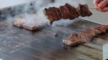 Şef, Japon Wagyu bifteğini ya da etini alev makinesiyle şişledi. Izgara tava ve meşale ile nefis bir şekilde ızgara et. Japonya 'da canlı sıcak alevlerle sokak yemekleri hazırlığı