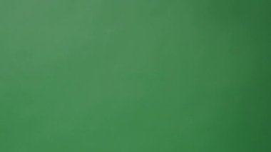 Yeşil ekran arka planında Eller tarafından alkışlanan el çırpma tahtası. Film yapımcısı yeşil kamera çerçevesinde film tahtasını vurdu. Alkış tahtası Chroma anahtar atışı. Yeşil ekran kompozit video üretimi.