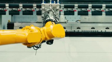 Vakumlu vakum bardaklı demo sarı robotik kol metal bükme işlevlerinde otomasyon gösteren bir fren makinesinin önünde çalışıyor. Gelişmiş otomatik üretim yüksek hassasiyet teknolojisi 