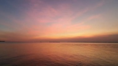 Sakin bir denizin üzerinde sakin bir günbatımı. Gökyüzünün altın rengi pembe ve mavi renkleri suya yansıyor. Sakin bir atmosfer huzur verici nefes kesici bir sahne yaratıyor. Rahatlamak için mükemmel..