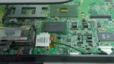 Bir bilgisayar anakartını kapatırken lazer taramasında hata oluştu. Modern Ai bilgisayarında entegre devreler, bağlayıcılar ve anahtar bileşenler taranıyor..