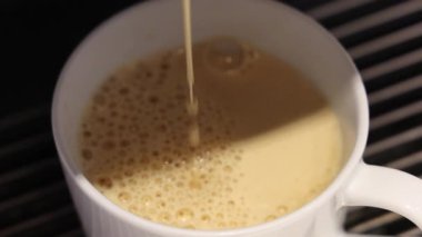 Kahve dolduruyorum. Beyaz bardağa dökülen yeni demlenmiş kahvenin yavaş çekimini kapat. Yumuşak köpüklü yüzey. Sıcak Americano ya da Espresso kahvesi. Kahve için kahve fincanındaki zengin aroma..