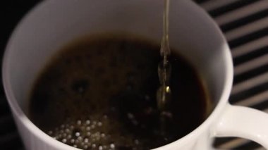 Kahve dolduruyorum. Beyaz bardağa dökülen yeni demlenmiş kahvenin yavaş çekimini kapat. Yumuşak köpüklü yüzey. Sıcak Americano ya da Espresso kahvesi. Kahve için kahve fincanındaki zengin aroma..