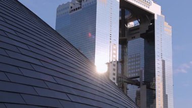 Osaka 'daki Umeda Gökyüzü Binası ve akşamları güneş ışığı. Şehir simgesi, tepesinde ikiz kuleleri birbirine bağlayan eşsiz bir yüzen bahçe gözlemevi barındırıyor. Umeda Gökyüzü Binası Osaka Tarihi Yerleşim yerlerinden biri.