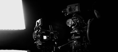 Üst düzey profesyonel sinema kameraları, kamera ekipmanlarını ve set elemanlarını aydınlatan film ya da video yapım kurulumu. Kamera arkasında ya da sinematik görüntüler için bir stüdyoda BTS video çekimi.