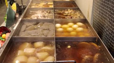 Oden 'in dumanı tüten bir gösterisi. Oden, konjac balığı kekleri ve lezzetli bir et karışımının içinde kaynamış daikon yumurtalarından oluşan geleneksel bir Japon yemeği. Osaka Japonya 'da Oden popüler sokak yemekleri.