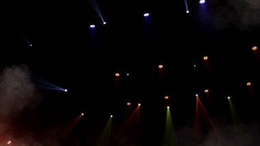 Sahne ışıkları arka planı. Gösteri zamanı sahnenin sahne ışıklarından ışık ve duman geliyor. Lazer göstergesi siyah arkaplanda izole edildi. Işık projektörü aydınlatmalı boş sahne.