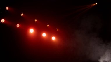 Sahne ışıkları arka planı. Gösteri zamanı sahnenin sahne ışıklarından ışık ve duman geliyor. Lazer göstergesi siyah arkaplanda izole edildi. Işık projektörü aydınlatmalı boş sahne.