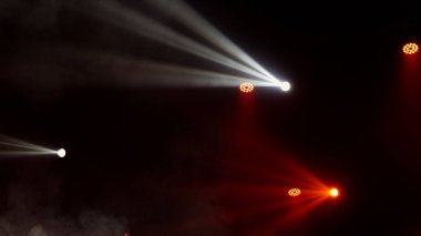 Sahne ışıkları arka planı. Gösteri zamanı sahnenin sahne ışıklarından ışık ve duman geliyor. Lazer göstergesi siyah arkaplanda izole edildi. Işık projektörü aydınlatmalı boş sahne.