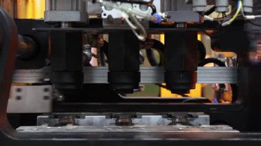 Endüstriyel üretim makinesindeki plastik PET şişesinin ısıtma işlemini kapat. Otomatik endüstriyel PET şişe makinesi. Yüksek hızlı plastik şişe üretiminde robot sistem otomasyonu.