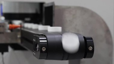 Plastik kapak yapımı. Modern fabrikadaki otomatik montaj makinesinde hareket eden plastik kapsüllerin tanıtımı. Endüstriyel plastik ambalaj ve şişe kapağı imalatında hassas mühendislik ve robotik.