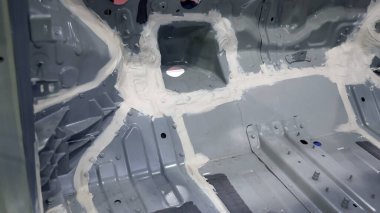 Araba gövdesi. Otomotiv şasisi ve iç vücut yapısı. Görünür kaynak dikişleri dolgu malzemesi uygulamaları ve titreşim sönümleme kağıtları. Araç şasisi yapısal takviye ve üretim hassasiyeti.