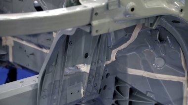 Araba gövdesi. Otomotiv şasisi ve iç vücut yapısı. Görünür kaynak dikişleri dolgu malzemesi uygulamaları ve titreşim sönümleme kağıtları. Araç şasisi yapısal takviye ve üretim hassasiyeti.