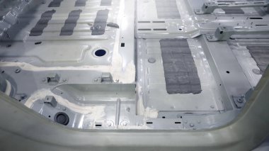 Araba gövdesi. Otomotiv şasisi ve iç vücut yapısı. Görünür kaynak dikişleri dolgu malzemesi uygulamaları ve titreşim sönümleme kağıtları. Araç şasisi yapısal takviye ve üretim hassasiyeti.