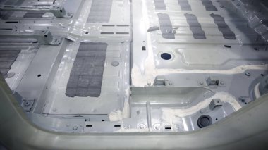 Araba gövdesi. Otomotiv şasisi ve iç vücut yapısı. Görünür kaynak dikişleri dolgu malzemesi uygulamaları ve titreşim sönümleme kağıtları. Araç şasisi yapısal takviye ve üretim hassasiyeti.