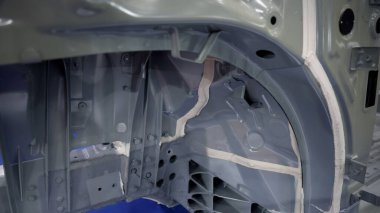 Araba gövdesi. Otomotiv şasisi ve iç vücut yapısı. Görünür kaynak dikişleri dolgu malzemesi uygulamaları ve titreşim sönümleme kağıtları. Araç şasisi yapısal takviye ve üretim hassasiyeti.