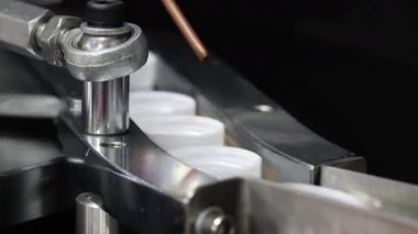 Şapka yapımı. Otomatik üretim hattı, endüstriyel makineler plastik kapakları bir taşıma sistemi üzerinde ayırıyor ve taşıyor. İlaç veya gıda endüstrisi ambalajı için teknoloji üretimi.