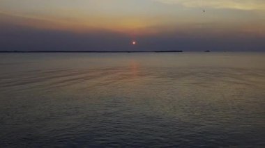 Gün batımı denizi. Bangpu Samutprakarn Tayland 'da güzel bir gün batımı ve renkli gökyüzü. Sıcak turuncu ve mor tonlarıyla huzurlu okyanus manzarası alacakaranlıkta dingin ve rahatlatıcı atmosfer yaratıyor..