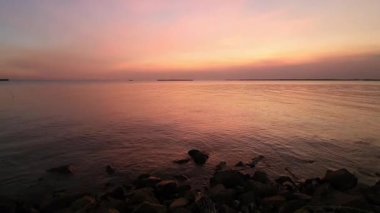 Gün batımı denizi. Bangpu Samutprakarn Tayland 'da güzel bir gün batımı ve renkli gökyüzü. Sıcak turuncu ve mor tonlarıyla huzurlu okyanus manzarası alacakaranlıkta dingin ve rahatlatıcı atmosfer yaratıyor..