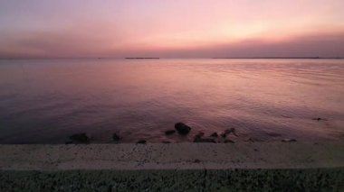 Gün batımı denizi. Bangpu Samutprakarn Tayland 'da güzel bir gün batımı ve renkli gökyüzü. Sıcak turuncu ve mor tonlarıyla huzurlu okyanus manzarası alacakaranlıkta dingin ve rahatlatıcı atmosfer yaratıyor..