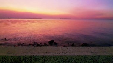 Gün batımı denizi. Bangpu Samutprakarn Tayland 'da güzel bir gün batımı ve renkli gökyüzü. Sıcak turuncu ve mor tonlarıyla huzurlu okyanus manzarası alacakaranlıkta dingin ve rahatlatıcı atmosfer yaratıyor..