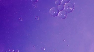 Su yağlı baloncuk. Soyut desenlerle sıvı içinde yüzen renkli baloncuklar. Yağ ve su etkileşimi renkli arka planda canlı şekiller yaratır. Bilim ve soyut sanat arkaplan animasyonu.
