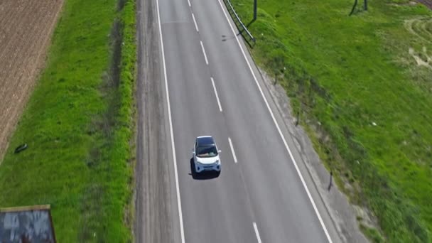 Biały Samochód Pasażerski Porusza Się Wzdłuż Autostrady Słoneczny Dzień Wideo — Wideo stockowe