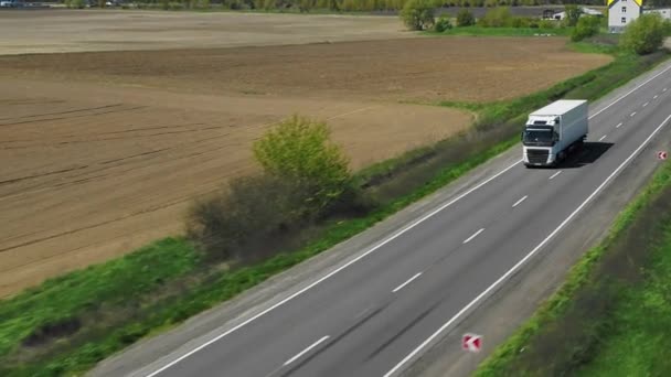 トラックは晴れた日に高速道路に沿って運転する 空中フォローショット 4Kビデオ — ストック動画