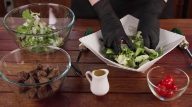 Yeşil salata hazırlarken, salata malzemelerini karıştırırken yavaş çekim. Sağlıklı yemek, vejetaryen yemeği.
