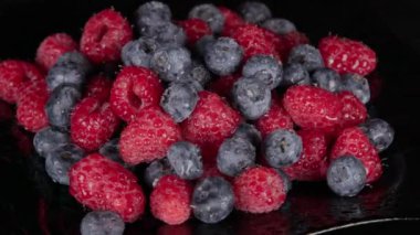 Böğürtlen Çeşitli renkli böğürtlen dönüşümlü arka plan. Nane yaprakları, çilek, ahududu, böğürtlen, böğürtlen, yakın plan dönen yabanmersini. Biyolojik meyveler, sağlıklı beslenme, vejetaryen yemekleri, diyet. 4K UHD video
