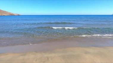 Kristal berrak denizin güzel manzarası. Dalgalar ünlü Ceneviz Sahili 'nin kumlu sahillerine ulaşıyor. Cabo de Gata, Almeria, Endülüs, İspanya.