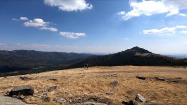 Puebla de la Sierra, Sierra del Rincon, Madrid, İspanya 'daki Pena Cabra rotasında bir dağın tepesinde yürüyen kız ve kadın panoramik
