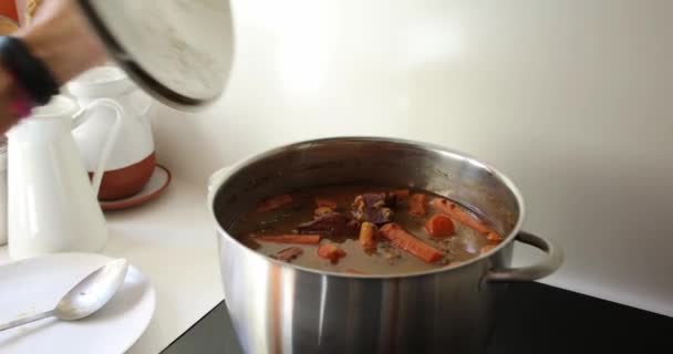女性はスペイン風の調理されたレンズ豆で大きな鍋を開きます — ストック動画