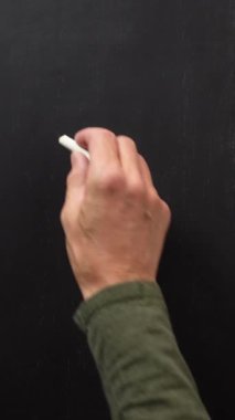 El, siyah tahtaya beyaz tebeşirle 3 numarayı yazıyor. Dikey video