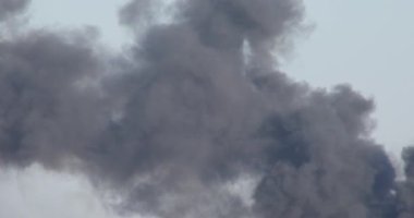 Mavi gökyüzündeki ateşten koyu yoğun siyah gri duman.