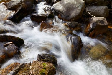 Uzun pozlama nedeniyle kayalar arasındaki nehir suyu akışı ipek etkisindedir