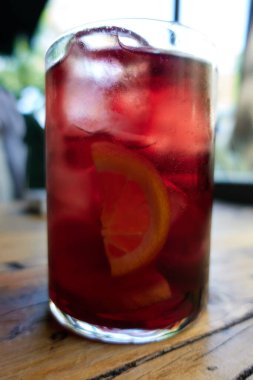 Büyük bardakta tipik bir İspanyol kokteyli. Kırmızı şarap ve soda. Tahta masada Tinto de Verano.