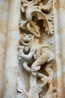 Meşhur iblis elinde iki kepçe dondurma heykeliyle Salamanca katedralinin kuzey cephesinde, Kastilya 'da ve Leon, İspanya' da Puerta de Ramos 'ta bir külah dondurma tutuyor.