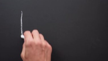 Bir el siyah tahtaya beyaz tebeşirle merhaba diyor.