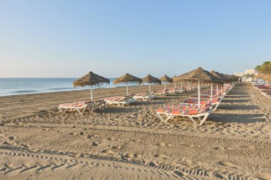 Torremolinos, Malaga, Endülüs, İspanya 'daki Los Alamos kumsalında şemsiyeler ve hamaklar