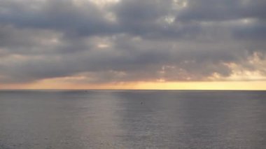 Denizdeki güzel ufuk çizgisi, şafakta ya da alacakaranlıkta bulutlarla hızlandırılmış. Gökyüzü ve okyanus dalgaları hızla ilerliyor