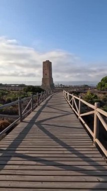 Artola Kumulları, Cabopino, Marbella (Malaga, Endülüs, İspanya, Avrupa) 'da bulunan 1500 yılından kalma tarihi Hırsızlar Kulesi' ne uzanan tahta patika boyunca yürümenin dikey görüntüsü.)