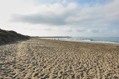 Cabo Pino 'nun ıssız plajında, kumlu sahile, ufuk çizgisine ve bulutlu gökyüzüne ulaşan dalgalar. Artola Dunes, Marbella, Malaga, Endülüs, İspanya