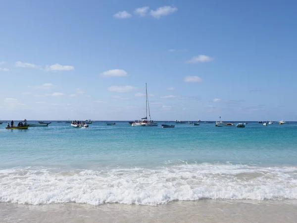 stock image Boats and waves of Atlantic Ocean in african Santa Maria town on Sal island in Cape Verde, clear blue sky in 2019 warm sunny spring day on April.