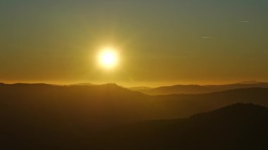 Polonya 'nın Szczyrk kasabası yakınlarındaki Avrupai Bialy Krzyz' deki Silesian Beskid Dağları üzerinde güneş batıyor. 2022 'de açık mavi gökyüzü, güneşli bir kış günü Kasım ayında..
