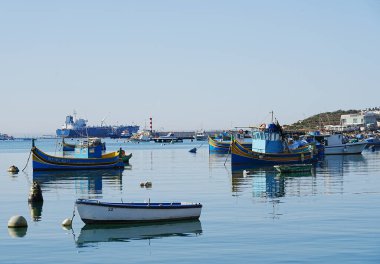 MARSAXLOKK, MALTA Mayıs 2022: Avrupa köyünün limanı, ılık güneşli bahar gününde açık mavi gökyüzü.