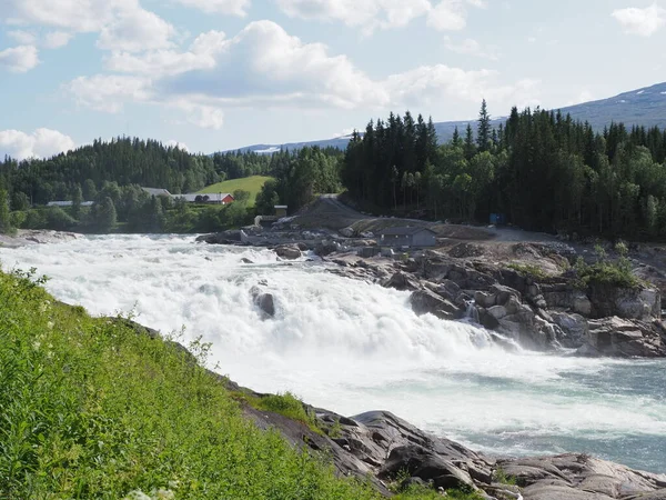 Norveç 'in Nordland bölgesindeki Avrupa Grane Köyü' ndeki Vefsna nehrinde Laksforsen şelalesi, sıcak yaz günü 2019 'da açık mavi gökyüzü..