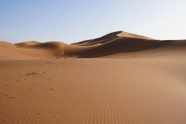 Afrika 'nın güneydoğusundaki Sahra Çölü' ndeki Erg Chigaga kum tepesine, Ocak 'ın 2023' teki güneşli kış gününde açık mavi gökyüzüne bakın..